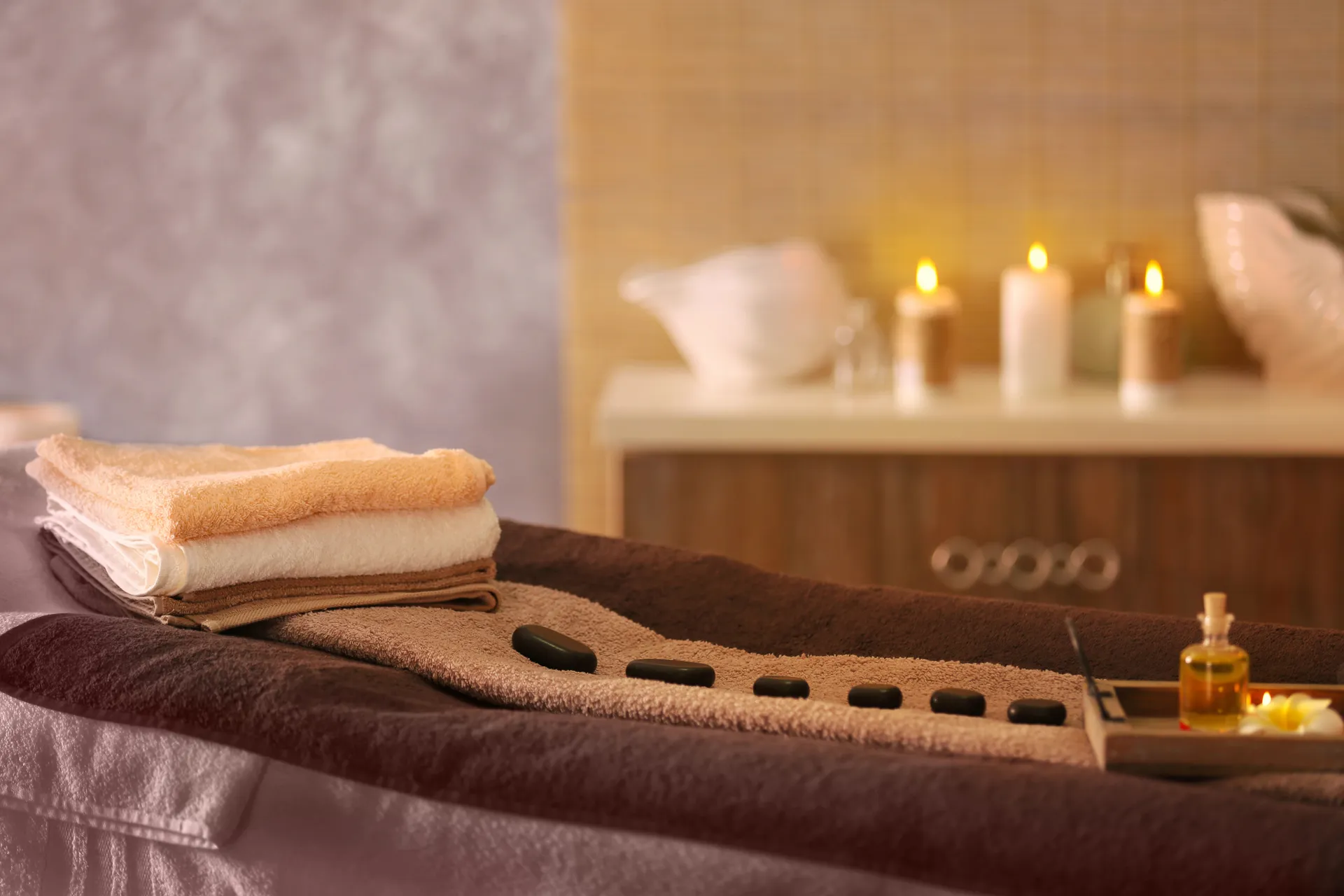Spa setting with hot stones, towels, and candles
